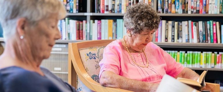 Two elderly females reading peacefully Two elderly females reading peacefully