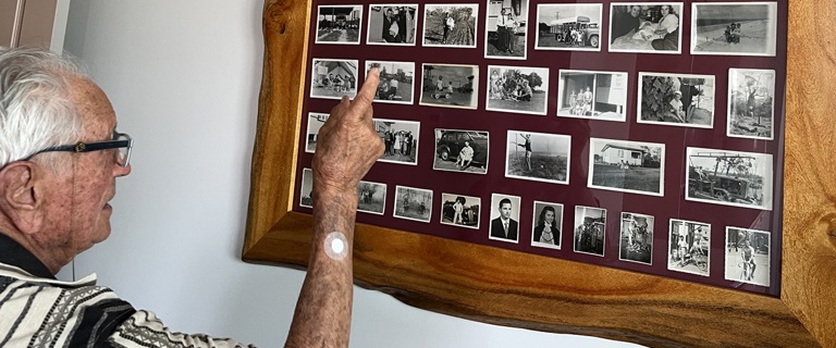 Frank looking through his photos from the early days of Caboolture.jpg Frank looking through his photos from the early days of Caboolture.jpg